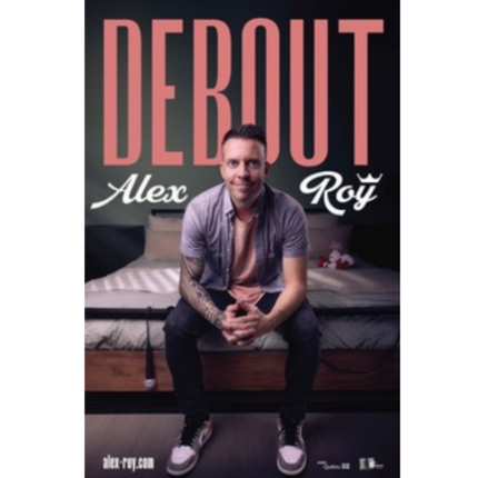 Alex Roy souriant en étant assis sur le bord d'un lit avec un micro pendant sur le bort du lit
